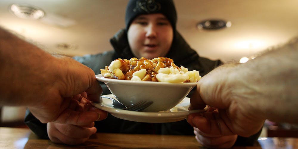 man waits for his plate of poutine
