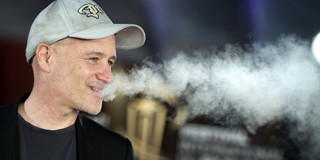 Older man blowing out smoke