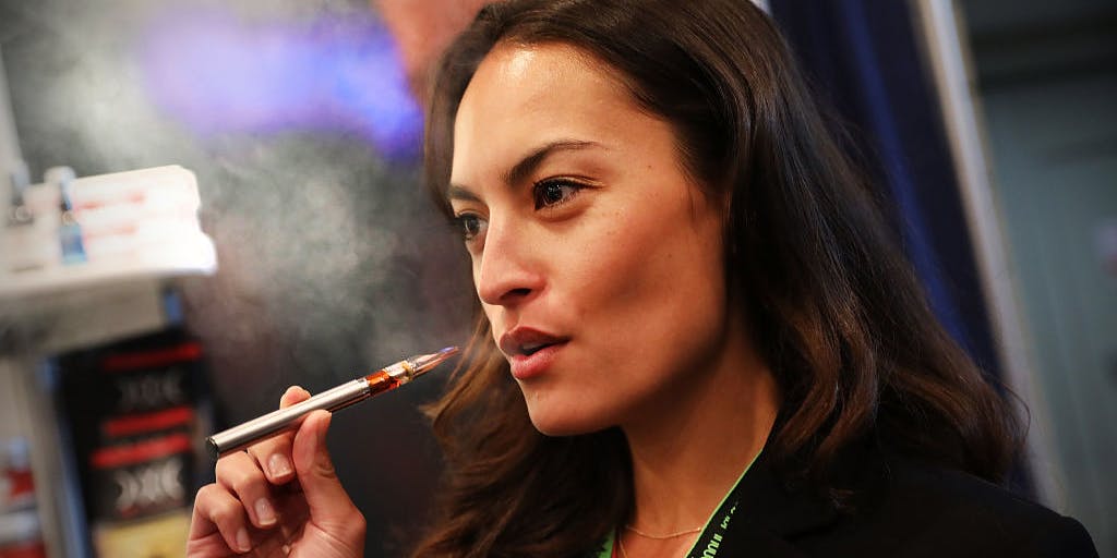 Women vapes a CBD oil made from hemp