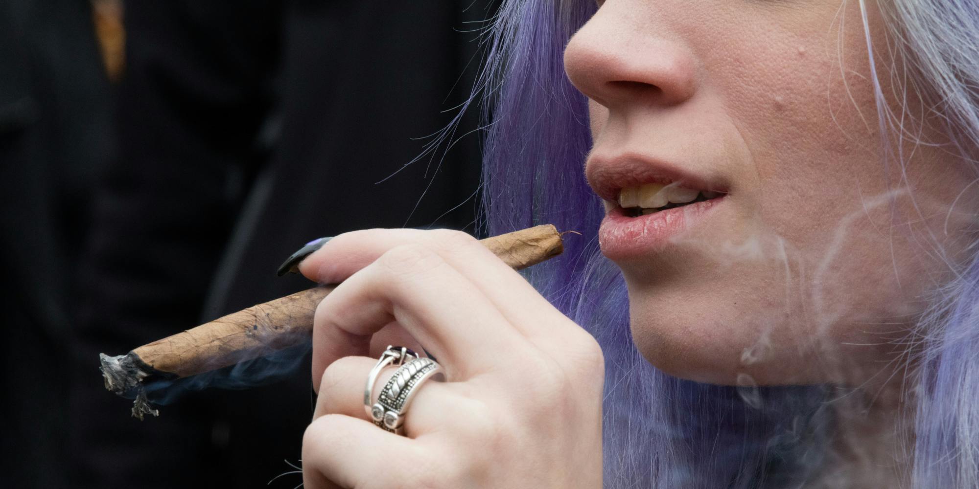 woman smokes cannabis during the annual NYC Cannabis Parade. Turns out women smoke more than men