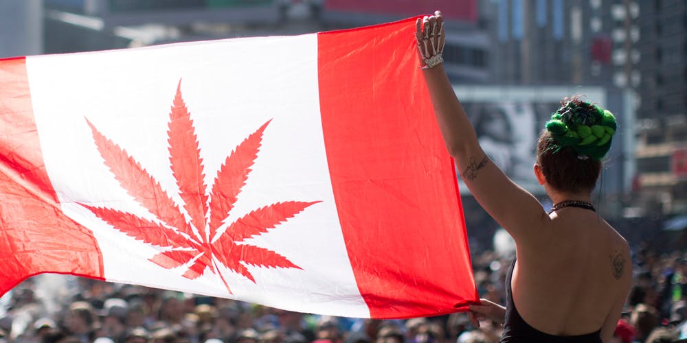 Woman holding up Cannabis Canada Flag