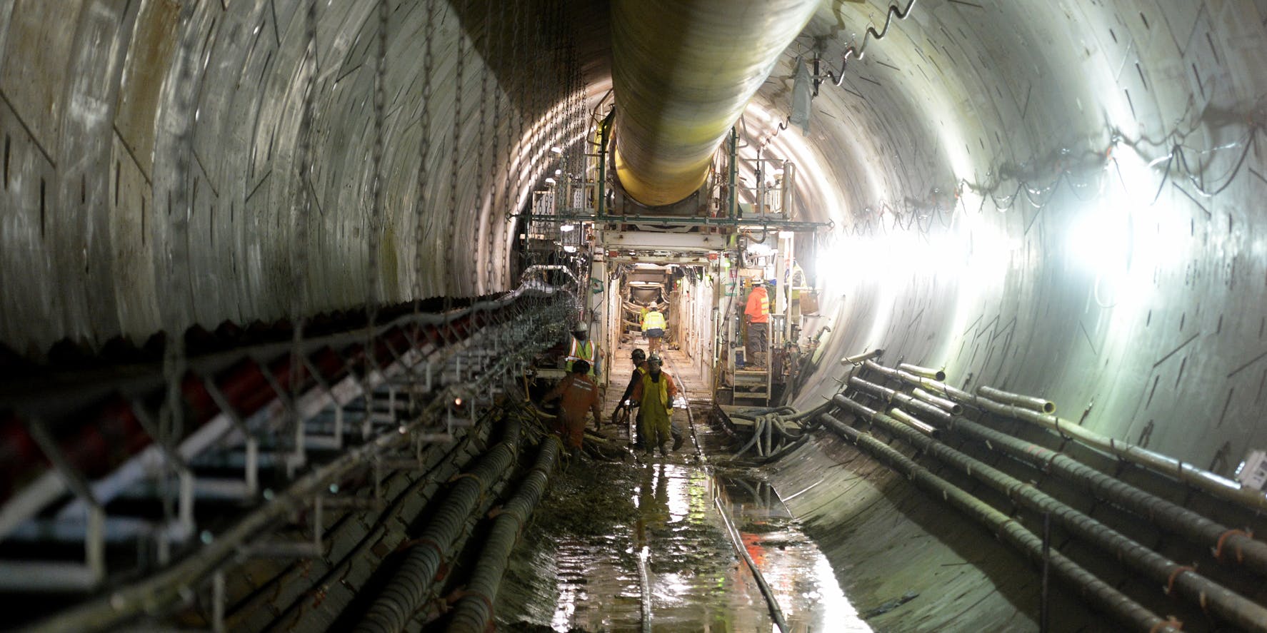 Construction workers about a mile into the new tunnel being constructed on the Clean Rivers Project. It is part of DC Water's program to reduce overflows from sewers into the Anacostia and Potomac Rivers and Rock Creek. (Photo by Jonathan Newton / The Washington Post via Getty Images)