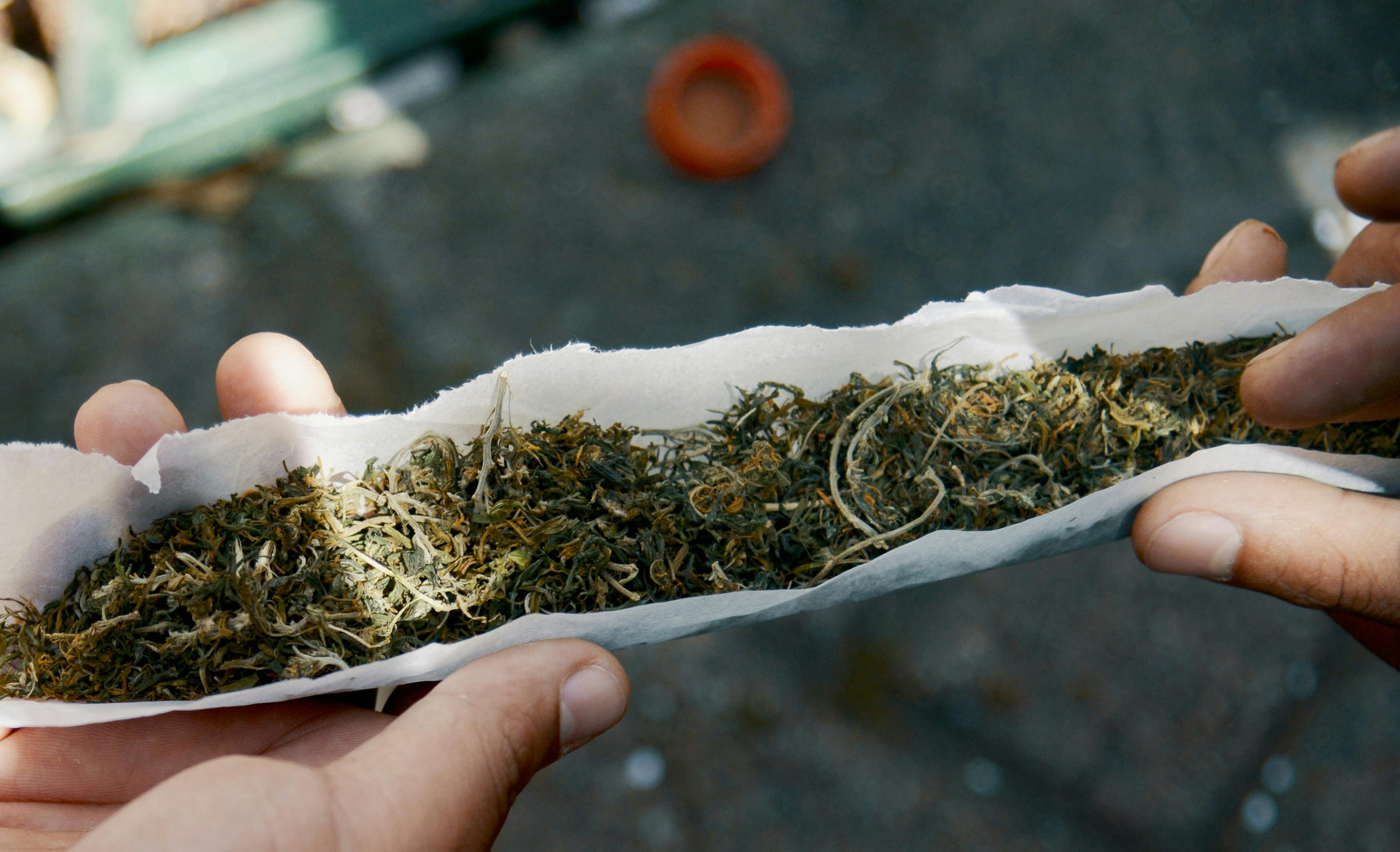 A youngster prepares a marijuana joint during the World Day for the Legalization of Marijuana in Medellin, Antioquia department, Colombia on May 3, 2014. In this article we feature all the cheapest weed in the world. Colombia ranks number two on that list