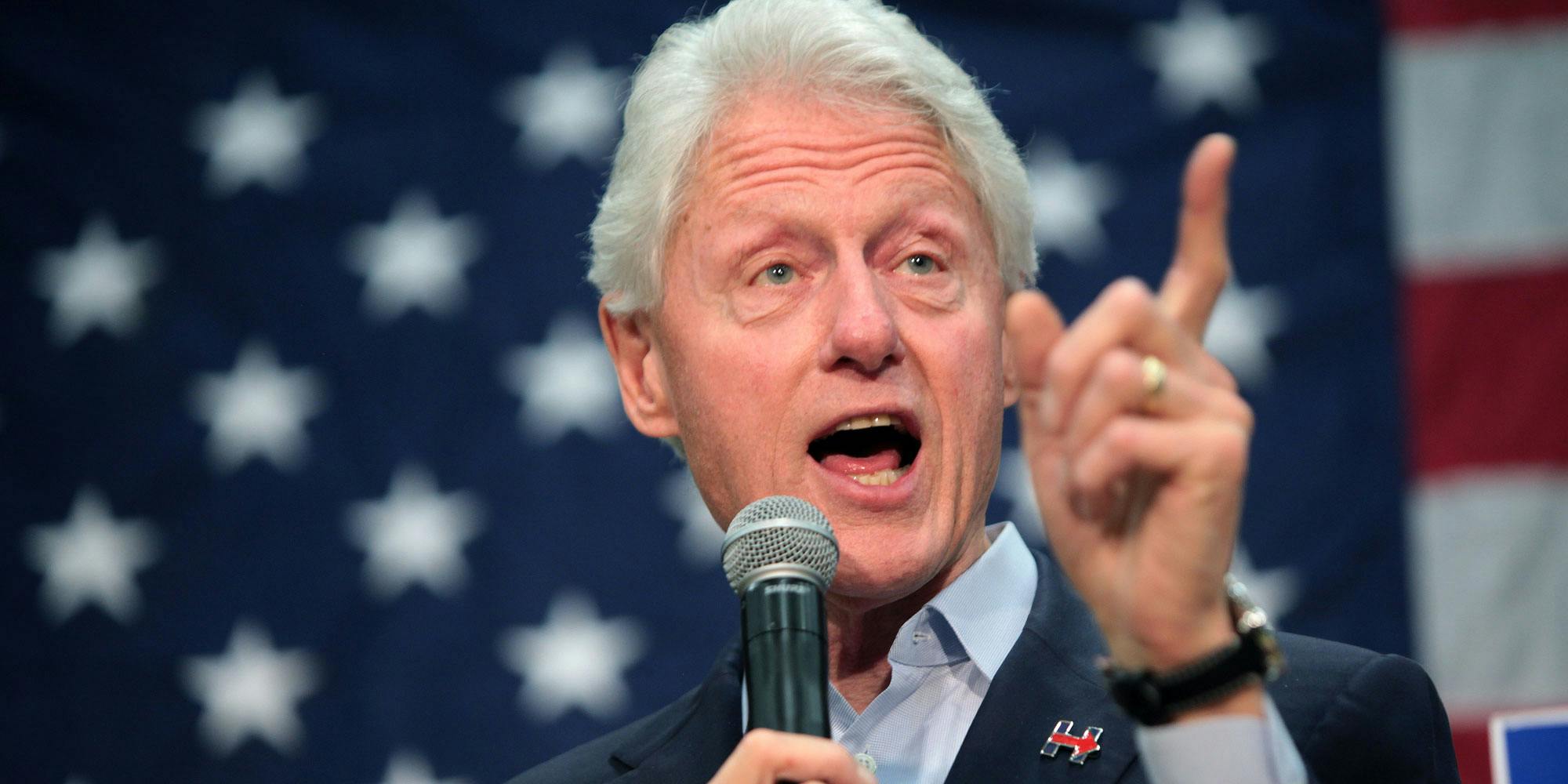 Bill Clinton pointing his finger in front of the American flag