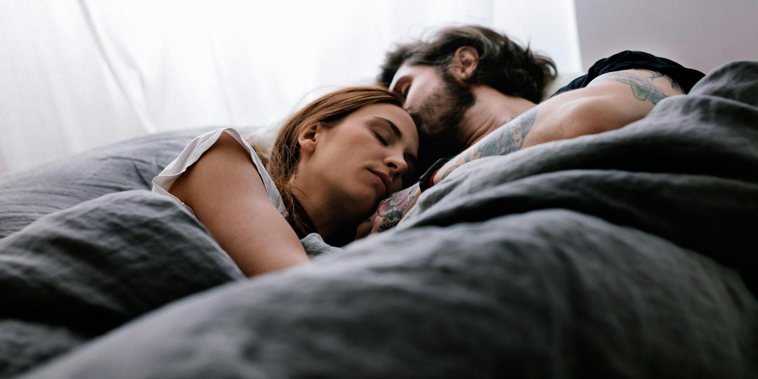 A couple is shown sleeping. In this article, we explore CBD for sleep