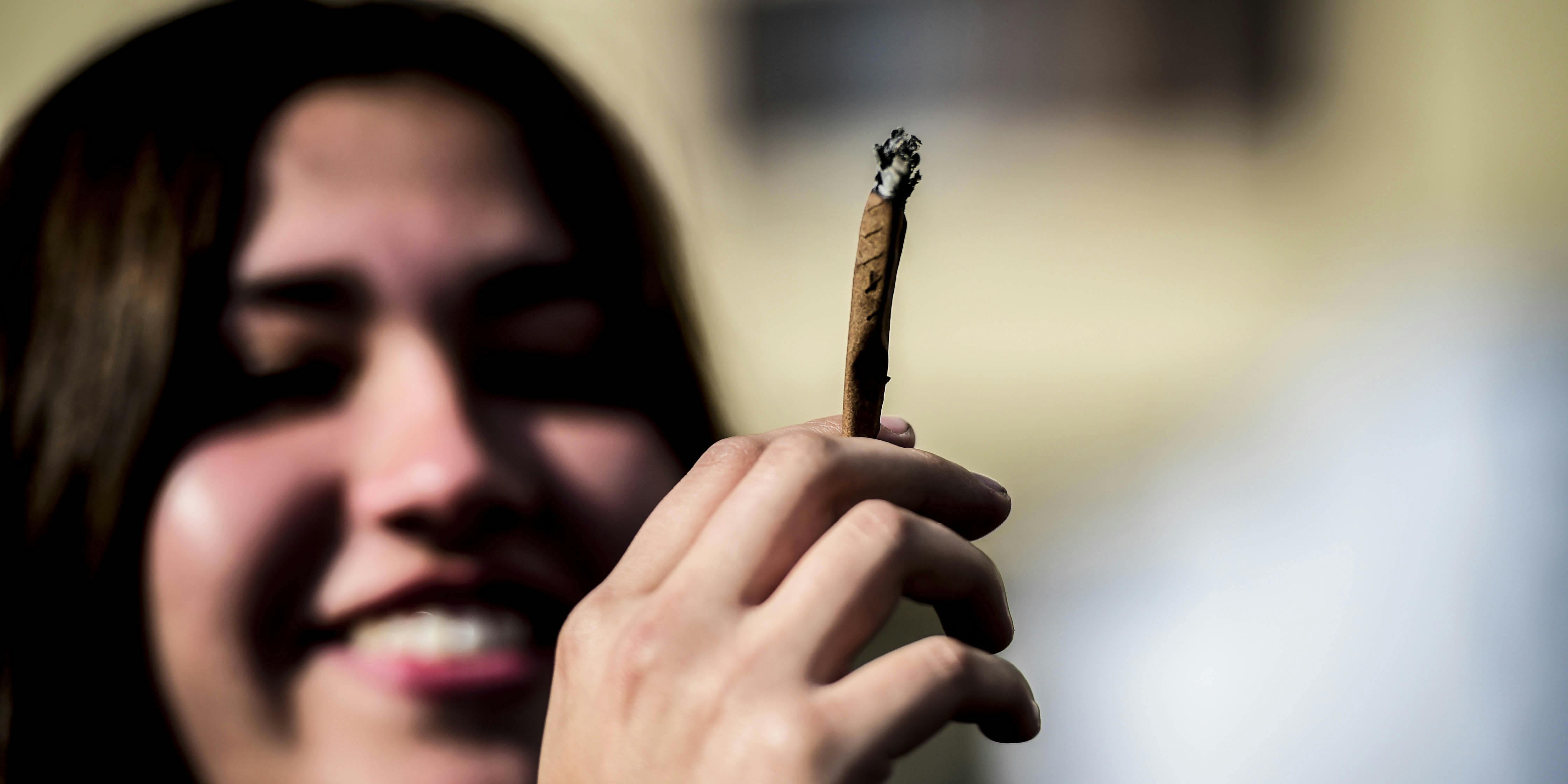 A demonstrator smokes a joint during a rally in Santiago in 2017. If legal cannabis is made too expensive, new research suggests that consumers will choose the black market over legal options.