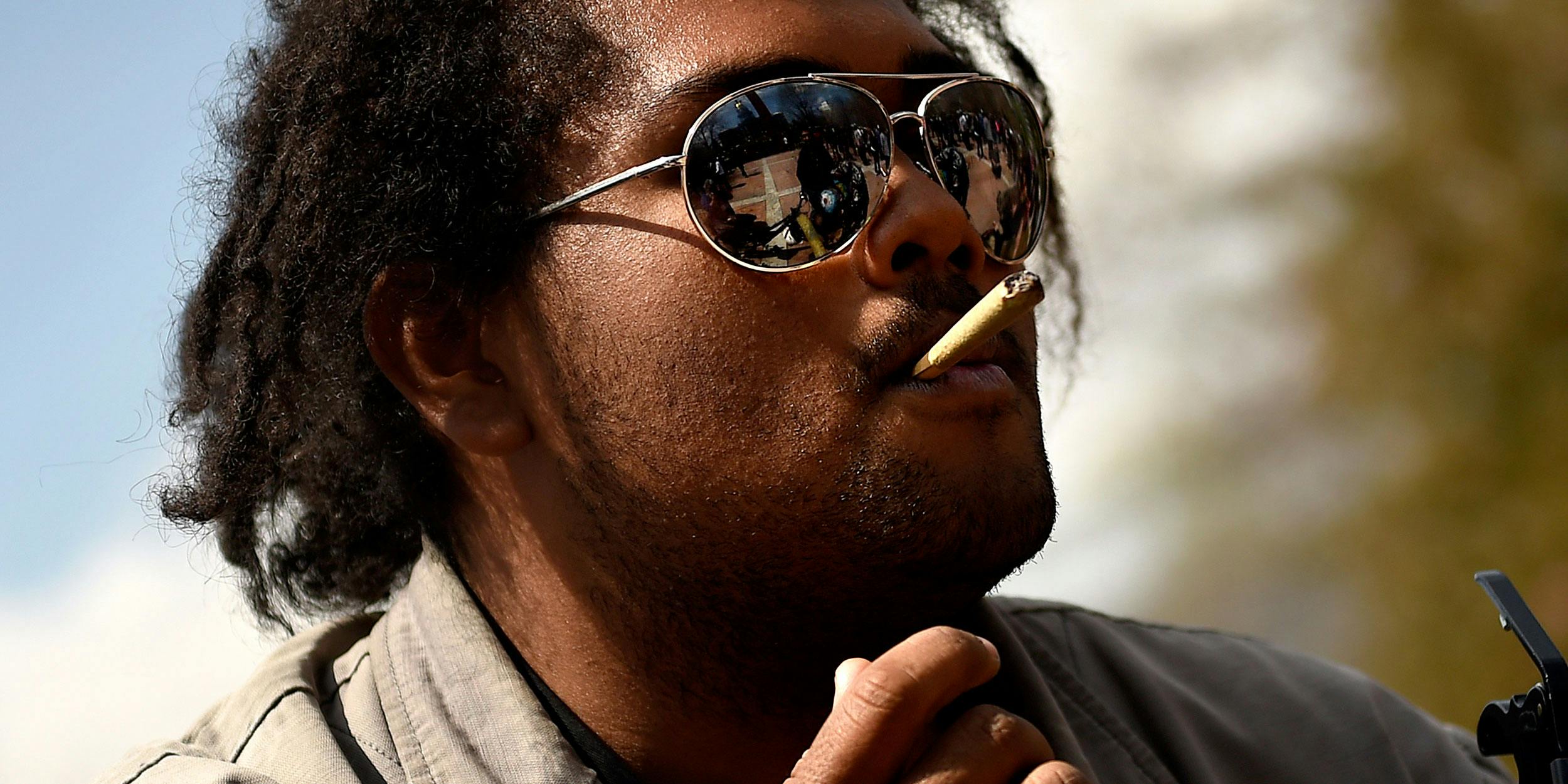 Miles of Phoenix, Arizona taking a smoke break from the guitar at the annual 420 smoke out celebration in Lincoln Park in downtown Denver on April 20, 2015. Photo By Joe Amon/The Denver Post via Getty Images)