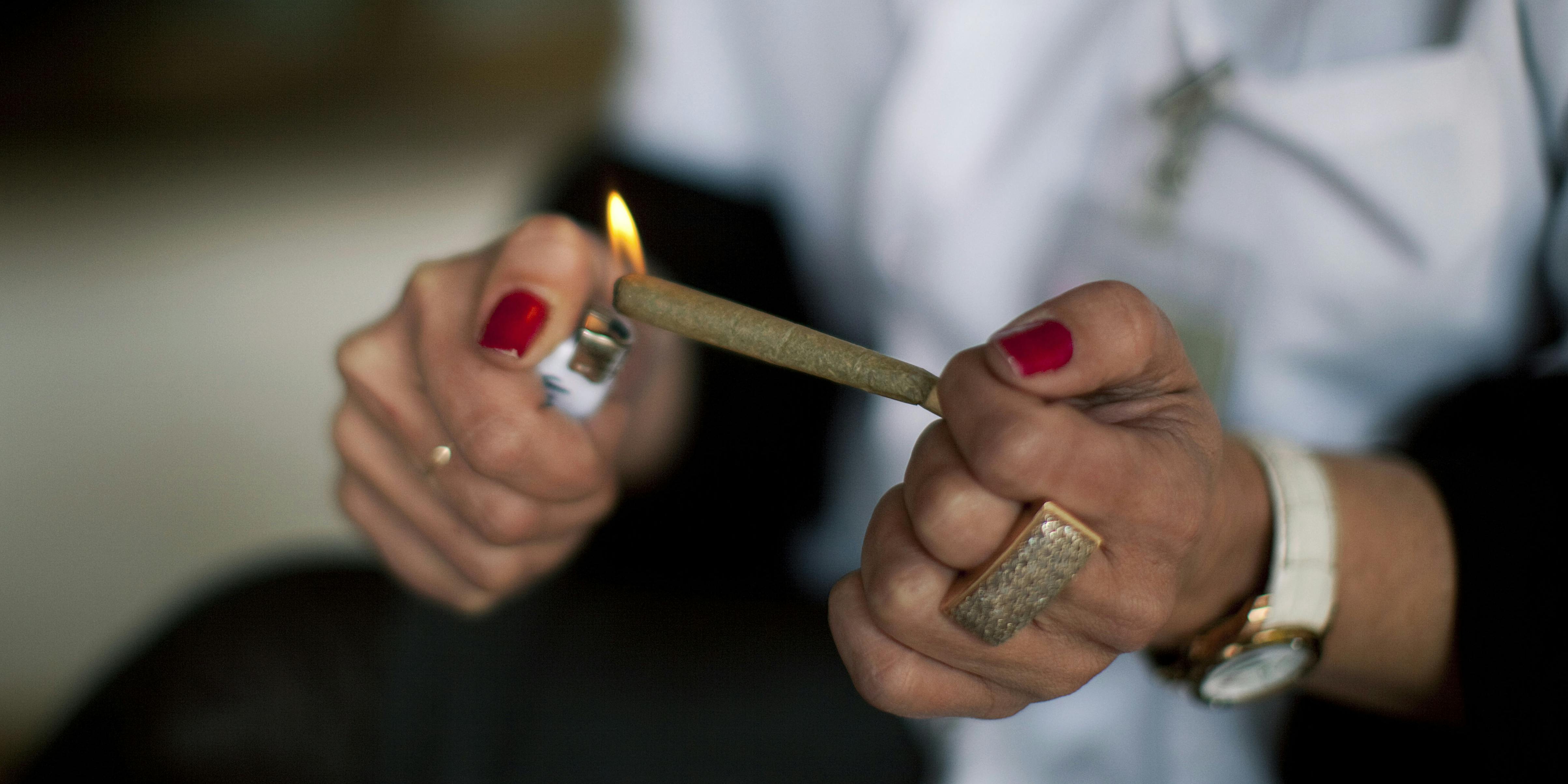 KIBUTZ NAAN, ISRAEL - MARCH 09: A nurse lights a cannabis cigarette for a patient at the Hadarim nursing home, on March 09, 2011 in Kibutz Naan, Israel. NiaMedic just announced it will bring the first clinic like it to America (Photo by Uriel Sinai/Getty Images)