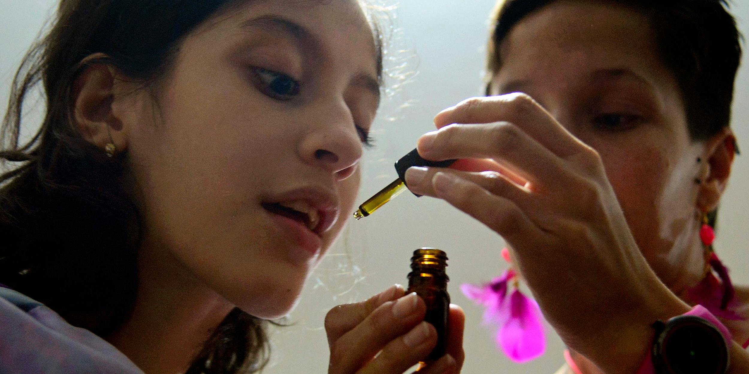 Colombian Ines Cano gives medical marijuana to her daughter Luna Valentina (L) at their home in Medellin, Antioquia department, Colombia on November 25, 2015. Valentina, 12, who was born with refractory epilepsy, started to use medical marijuana as an alternative medicine, which is the only solution which calms her seizures. Medical marijuana, or CBD more specifically, has shown promise in children with epilepsy.
