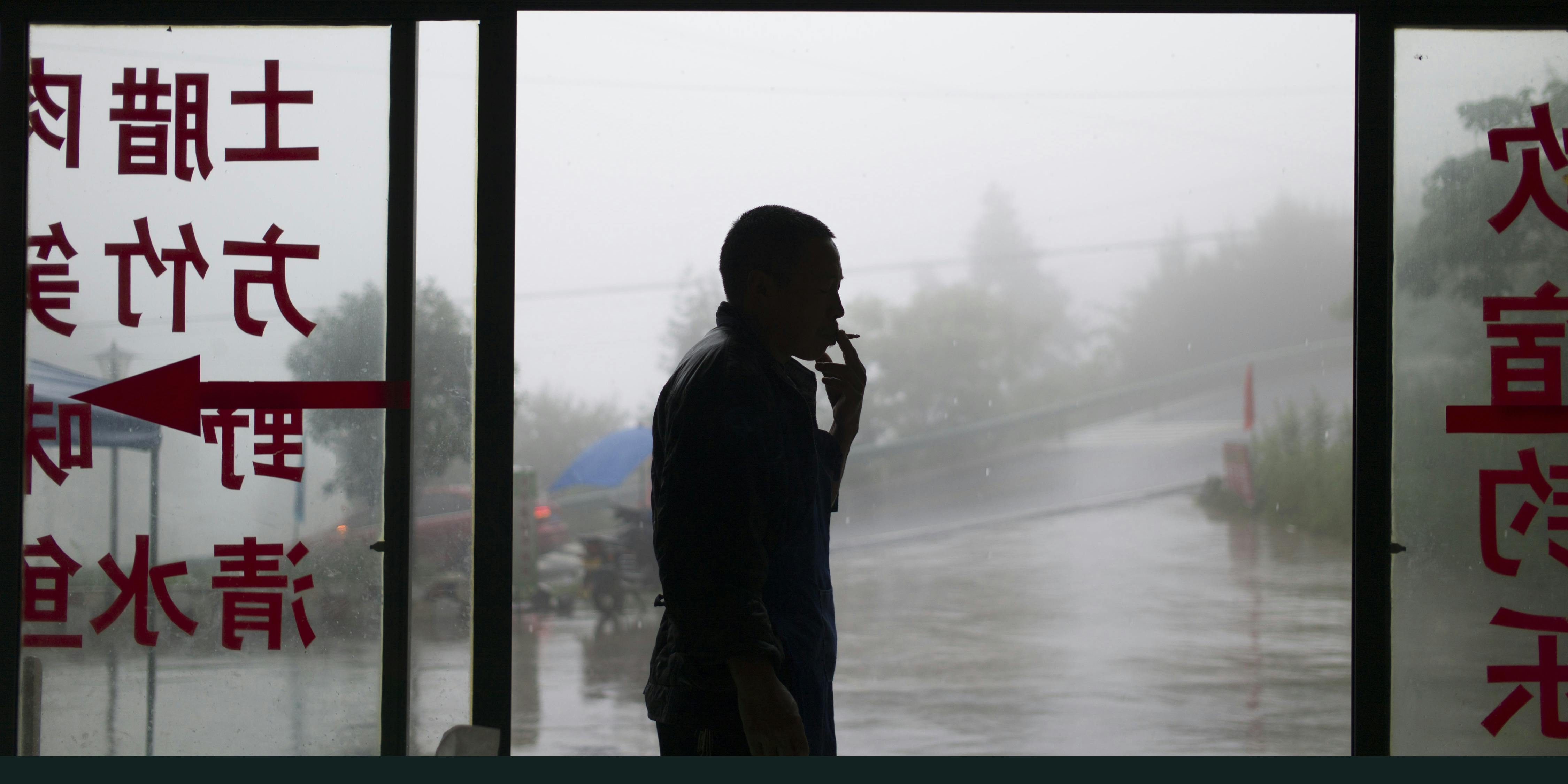 A man smokes on the outskirts of Chongqing, southwest China, on June 1, 2017. (Photo by Fred Dufour/AFP via Getty Images)