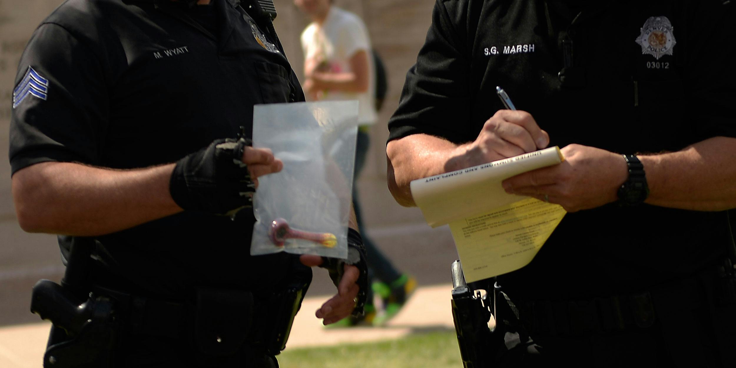 DENVER, CO. - APRIL 20: Denver bicycle police with their bagged evidence as they write one of two tickets to a group of four young men for smoking marijuana in public during the 420 celebration at the Denver 420 Rally in Civic Center Park on April 20, 2014. The El Paso Country Sheriff’s department is now keeping a database in an attempt to show that marijuana legalization increases crime. (Photo By Joe Amon/The Denver Post via Getty Images)