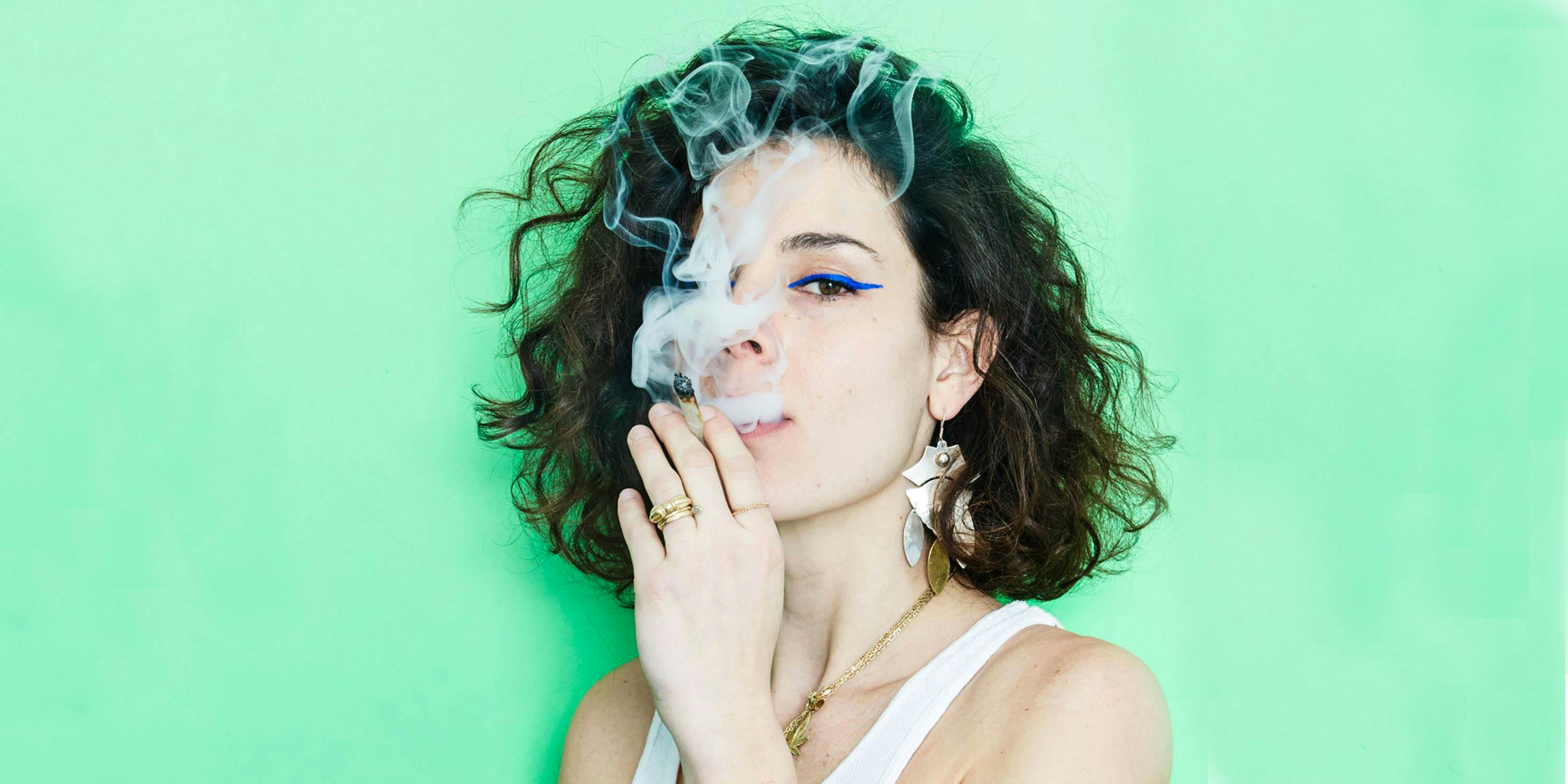 A woman smokes a joint. Cannabis is helping to make being a woman even better, whether it be weed lube for orgasms or CBD-infused bath bombs.