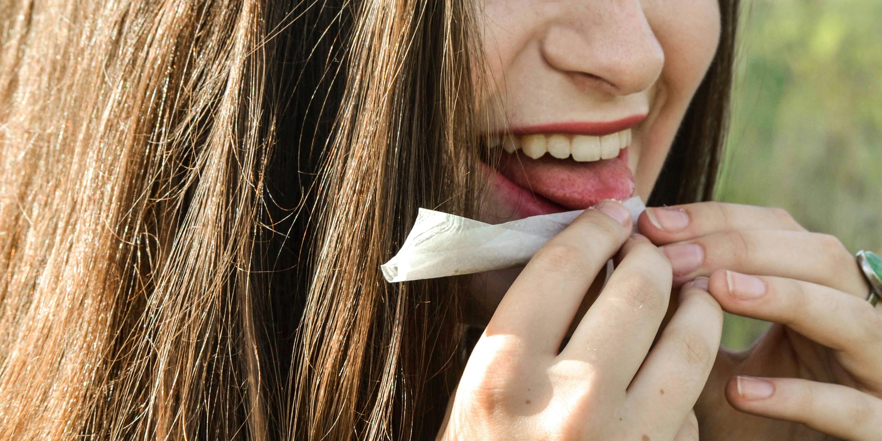 A girl finishes rolling a joint. If she finds herself in an argument with someone against cannabis, she may be able to identify their logical fallacy and change their mind.