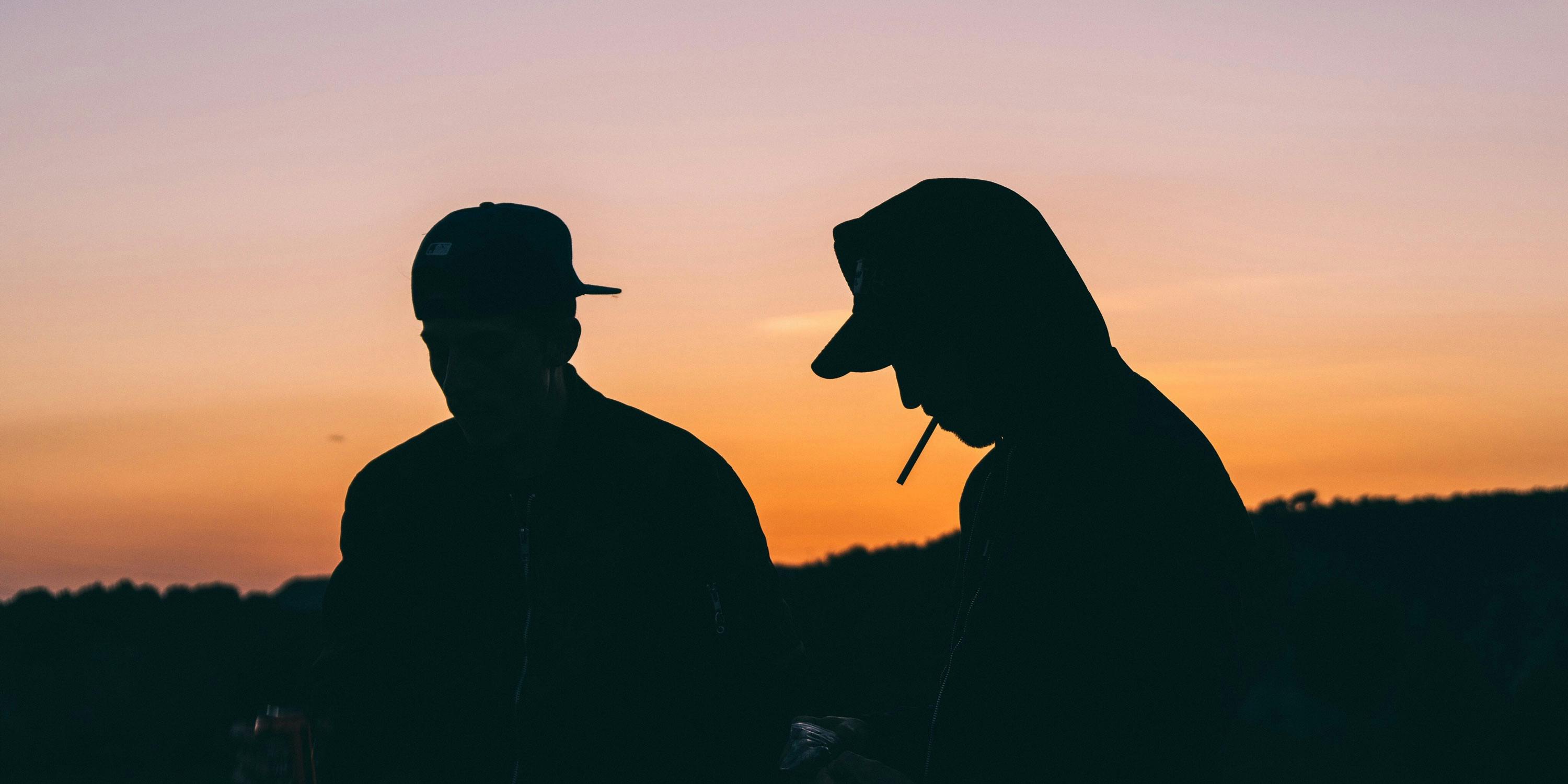Most universities prohibit weed smoking on campus. Here, two students are shown smoking at sunset