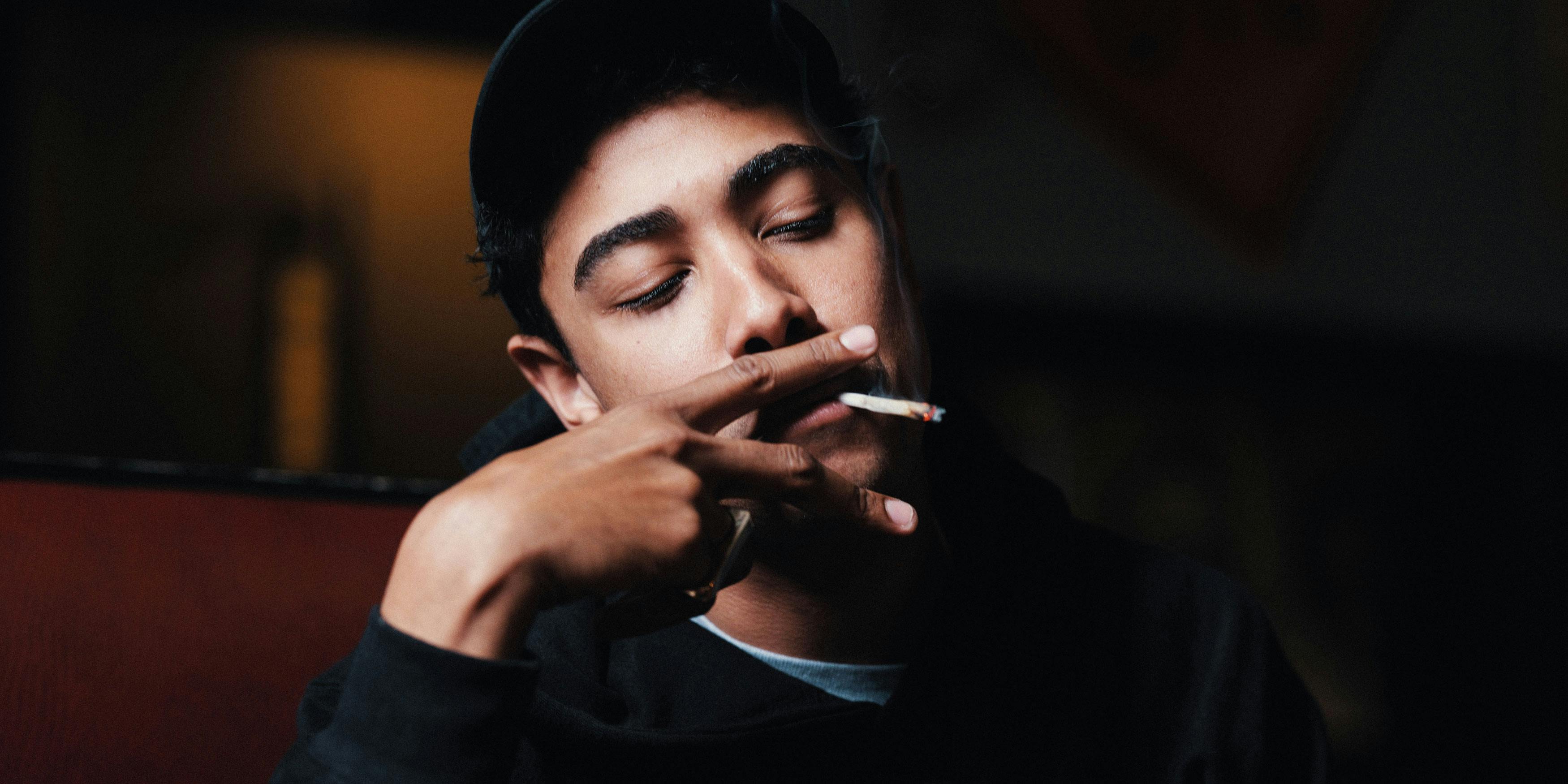 In this photo, a man is shown smoking a joint. We explore in this article why cannabis is the ultimate self-care tool