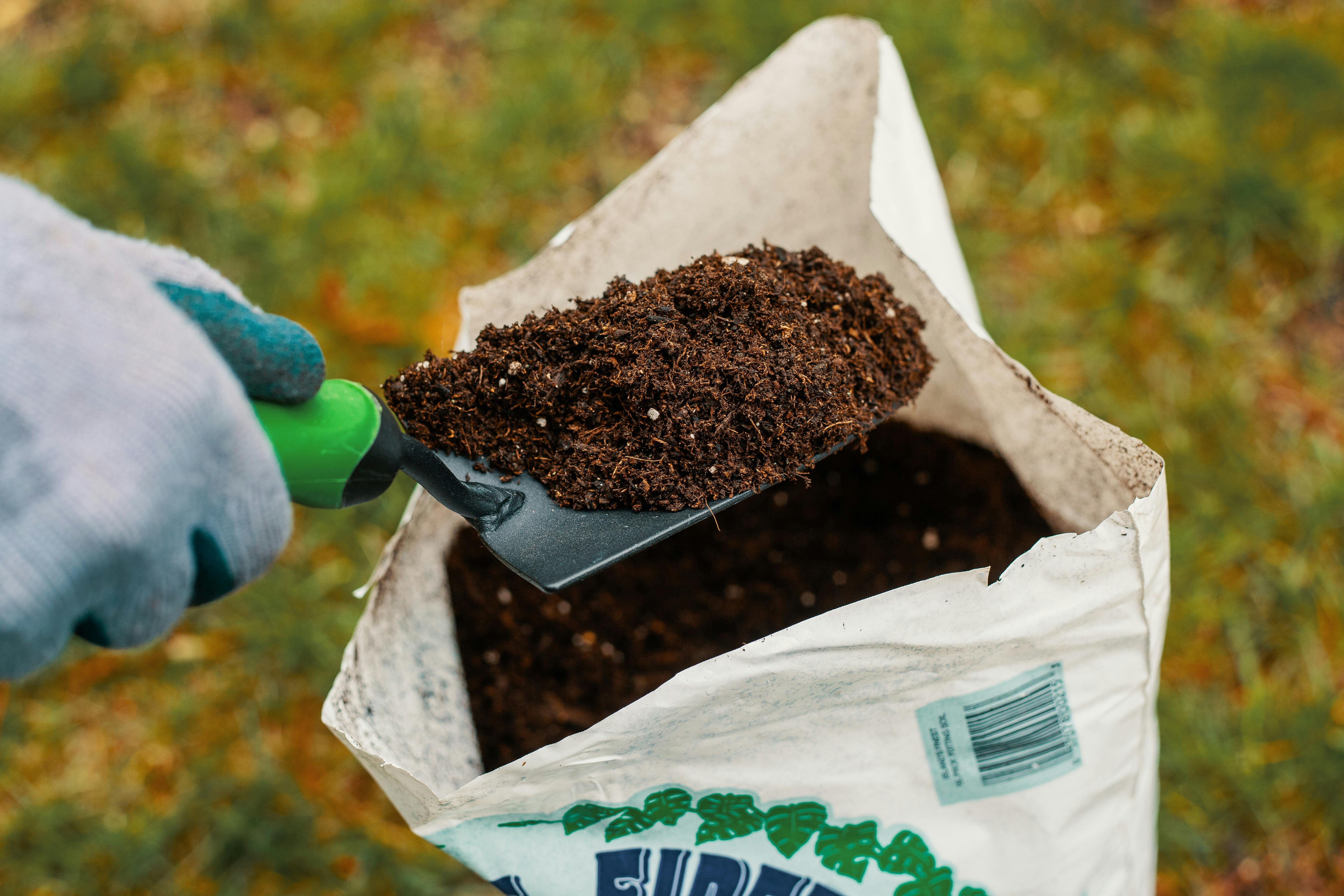 A man holds a shovel with cannabis nutrients