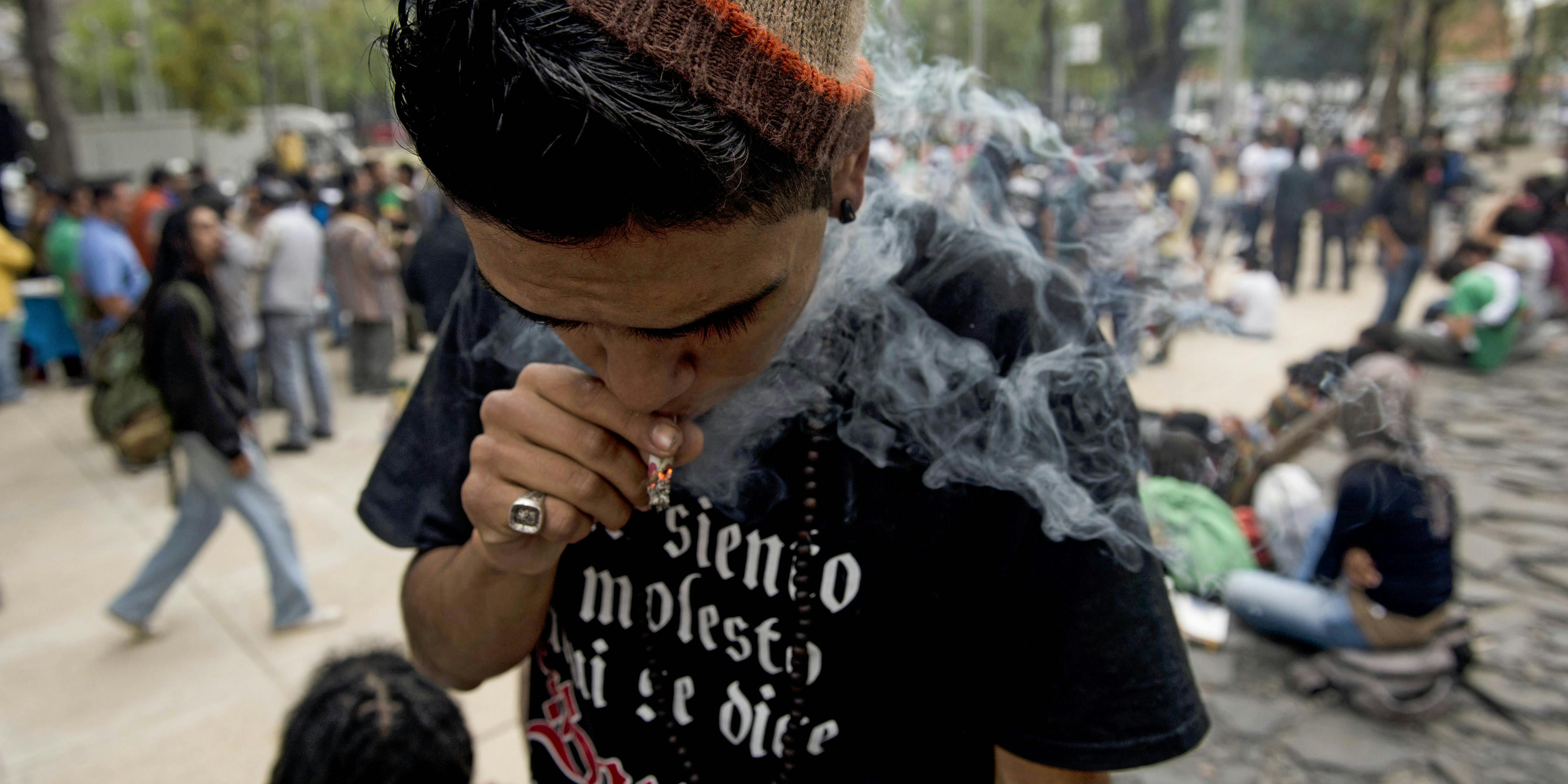 A man smokes cannabis during the "Marijuana Festival" in front of the building of the Mexican Senate. Mexico's supreme court rules cannabis prohibition unconstitutional.