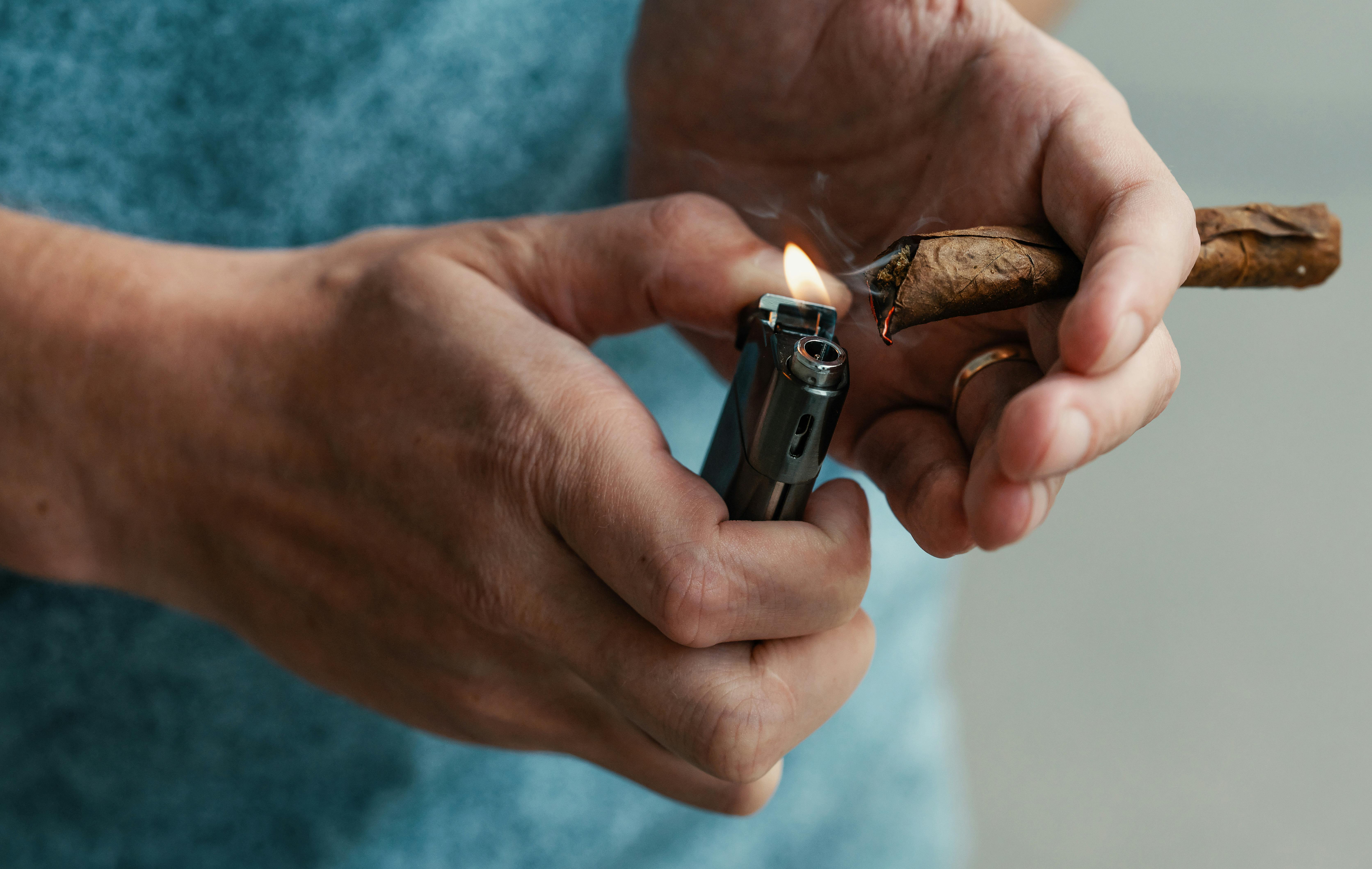 In this article, we feature the 10 best tobacco-free blunt wraps. Here, a man is shown lighting a blunt