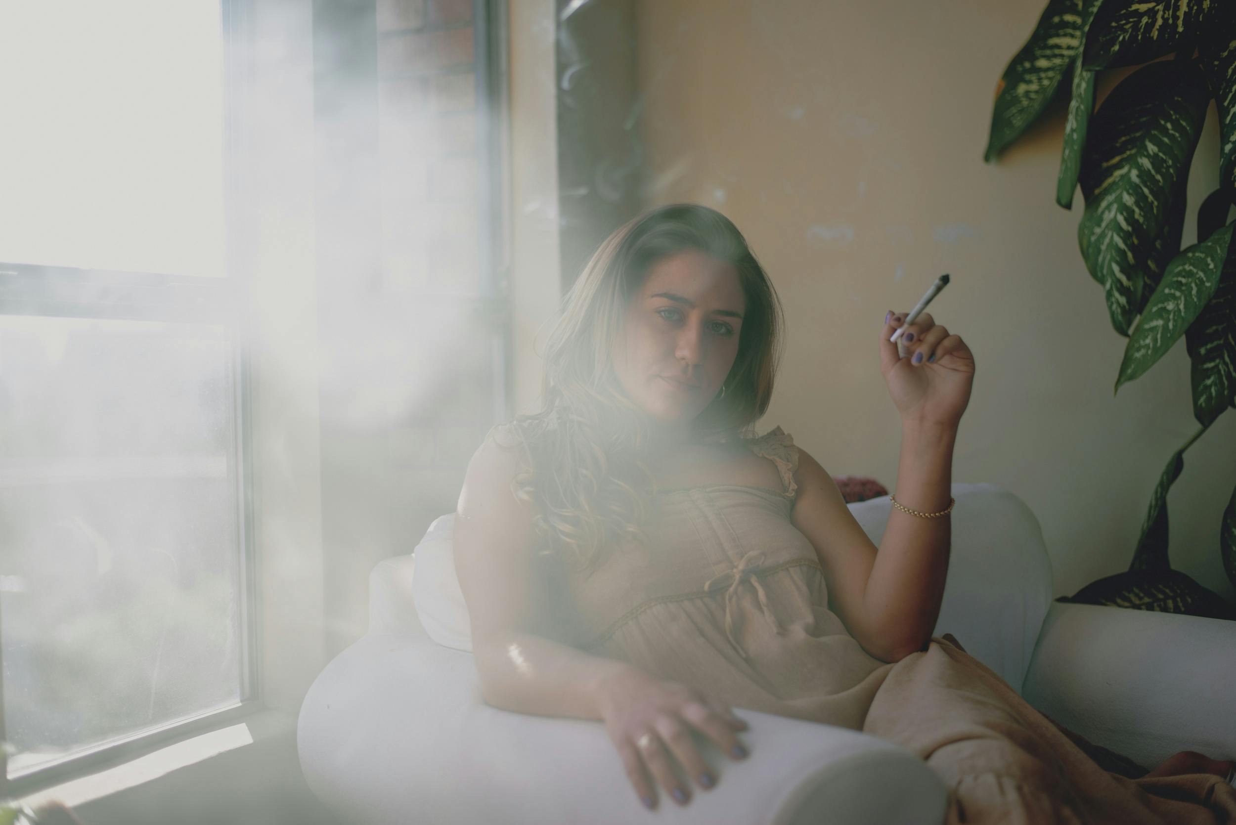 A woman reclines in a chair smoking one of the best pre-rolls.