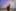 Standing before a skyline with a purple sunset, a man in a red hat with one of the best stash bags, the Skunk Bag, over his shoulder.