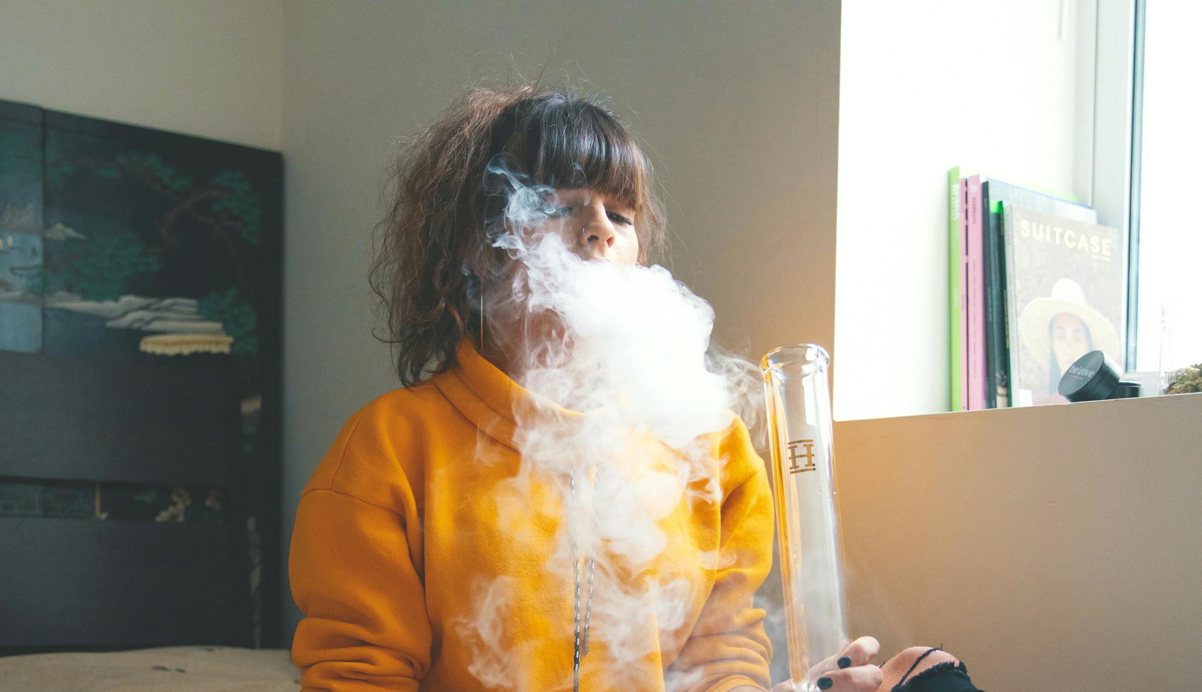 How to Make a Dab Station: A woman exhales a puff of smoke