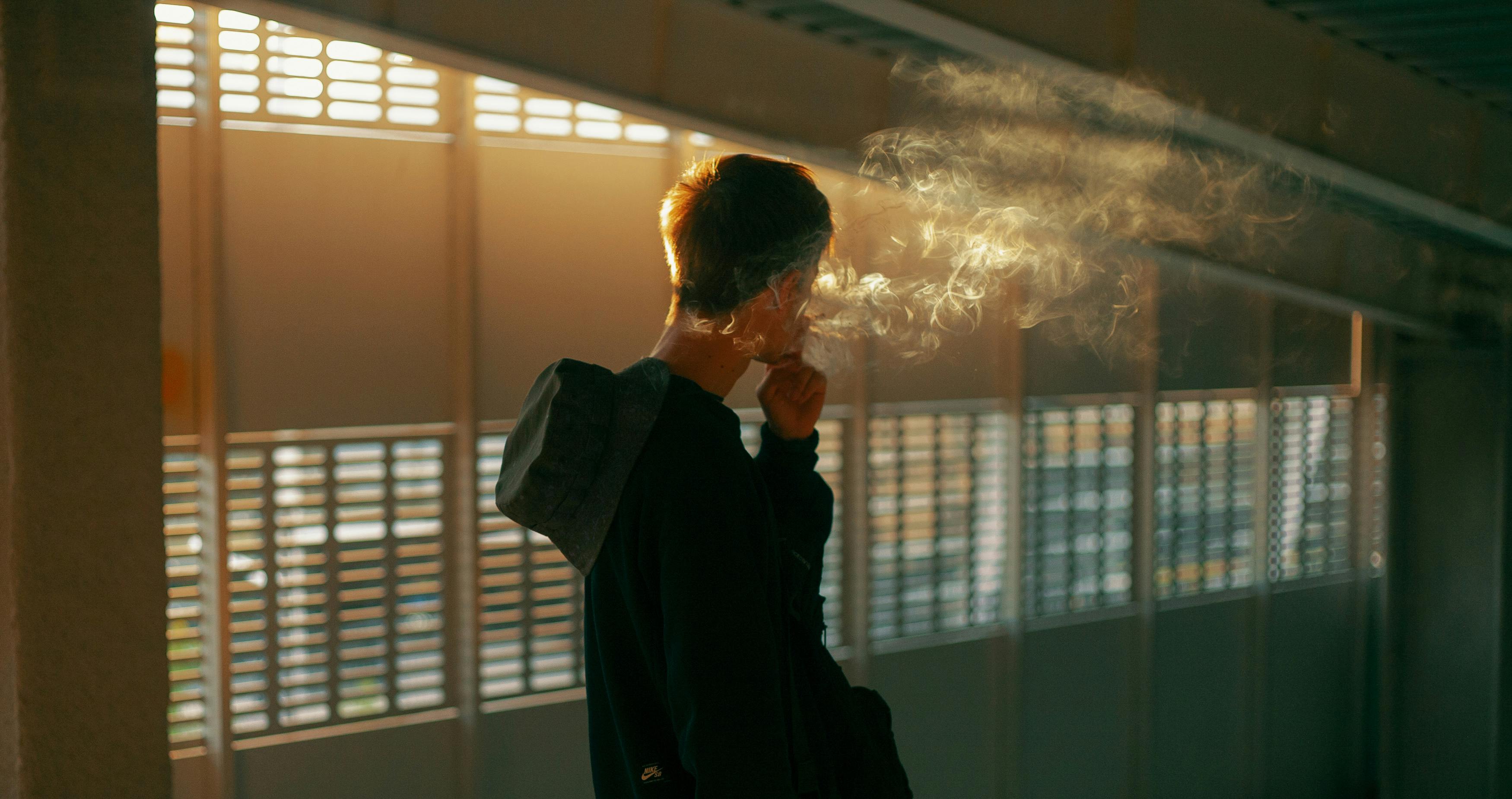 A man in a hospital window smoking weed after surgery